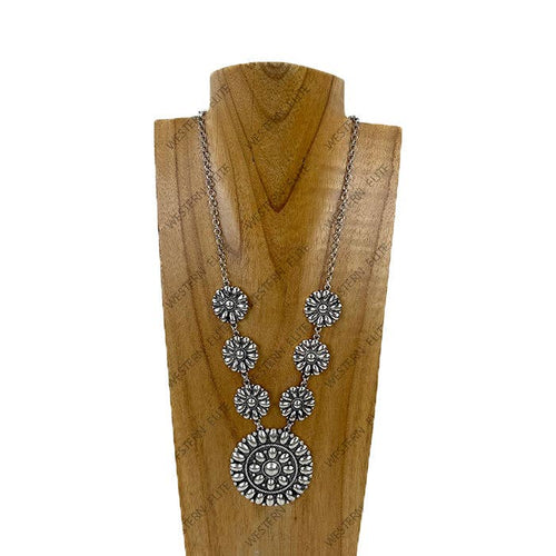 Silver necklace with floral designs on a wooden stand against a white background